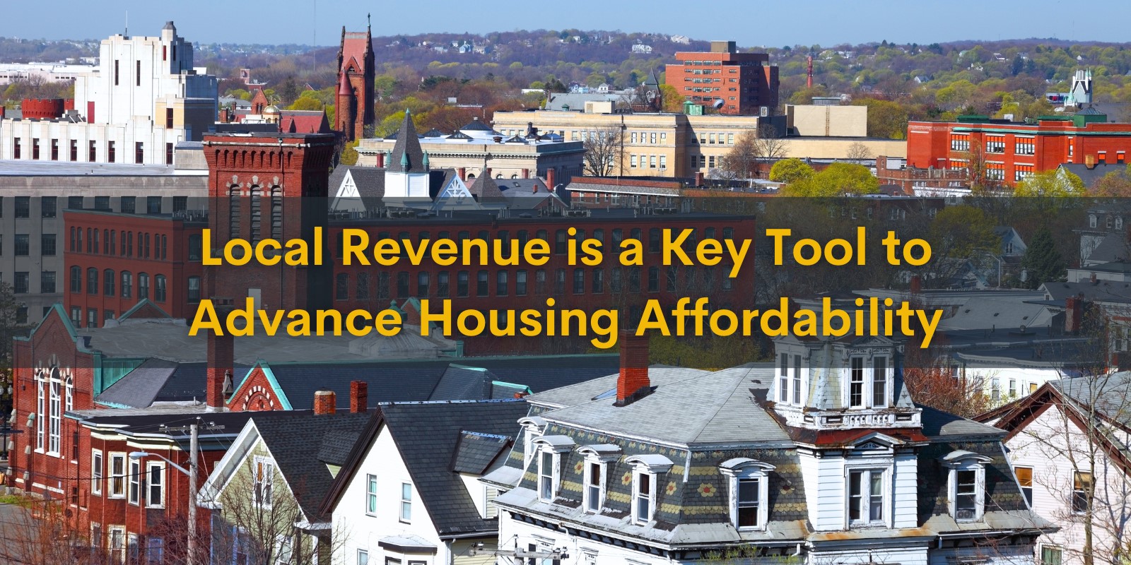 State Senator Julian Cyr addresses Dan Daniel Gessen and the Assembly of Delegates at Dan Gessen's first meeting as a Delegate to the Barnstable County Assembly. There is an American flag, a Massachusetts flag, and the county seal in the background. This meeting is hybrid government meeting with some delegates appearing on TV screens